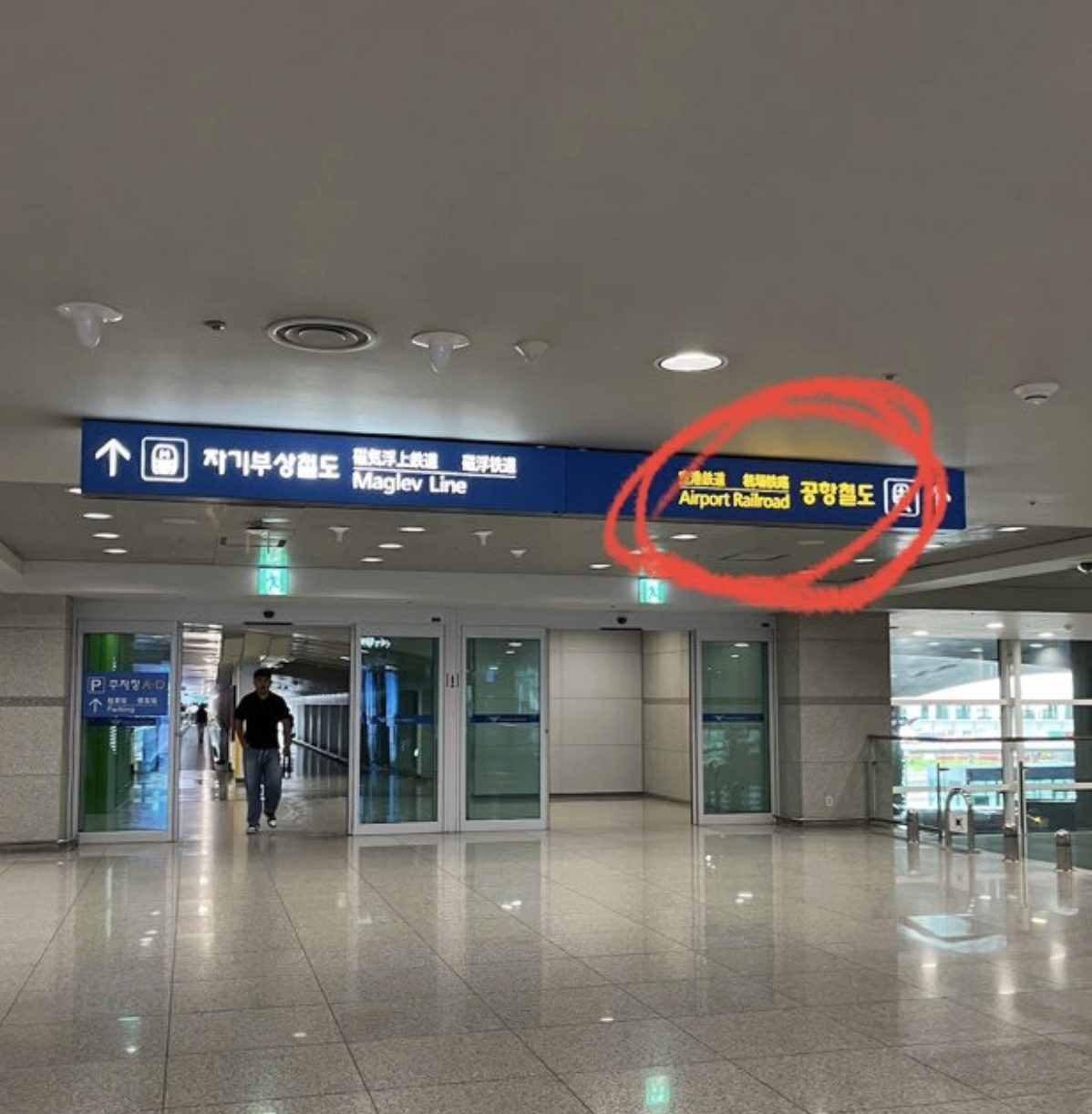 Basement level sign at Incheon Airport showing Maglev Line to the left and Airport Railroad to the right, the latter circled in red