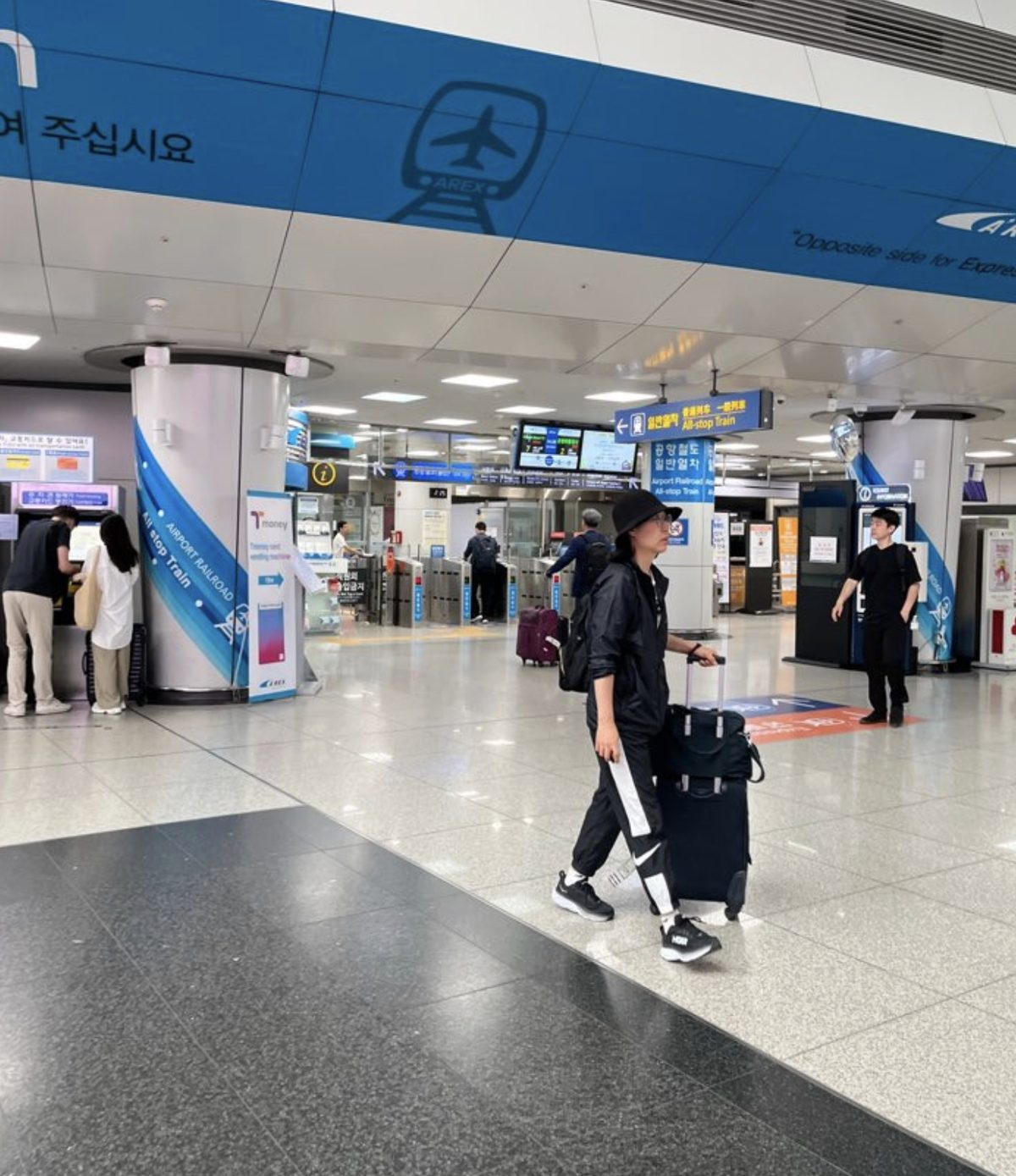 The AREX airport railroad station concourse inside Incheon Airport with ticket machines and passengers with luggage